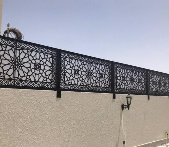 ساتر حديد أسود مقصوص بالليزر بنقوش هندسية إسلامية فوق سور منزل
